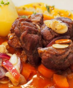 Schweinebaeckchen mit Gemuese und Kartoffeln auf dem Teller
